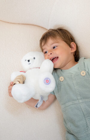 ours en peluche blanc 25cm dans les bras d'un enfant