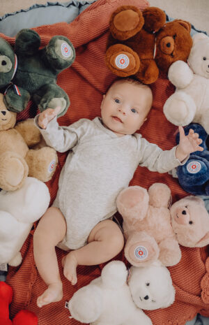 bébé entouré d'ours en peluche