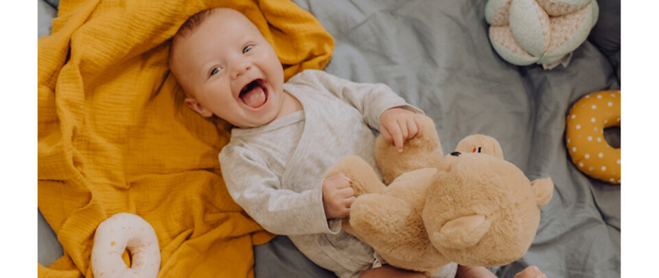 ours en peluche articulé et un bébé qui le manipule